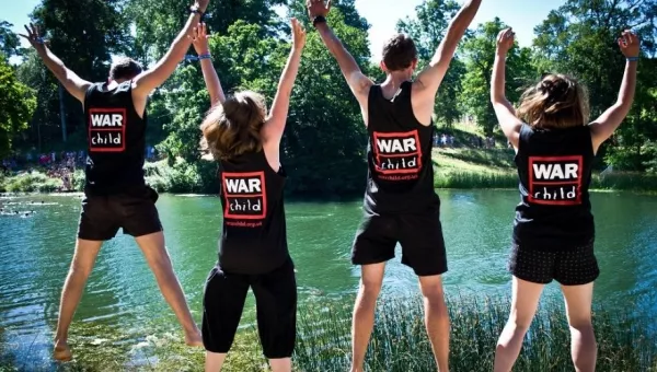 War Child staff jump in the air whilst volunteering at Wilderness Festival.