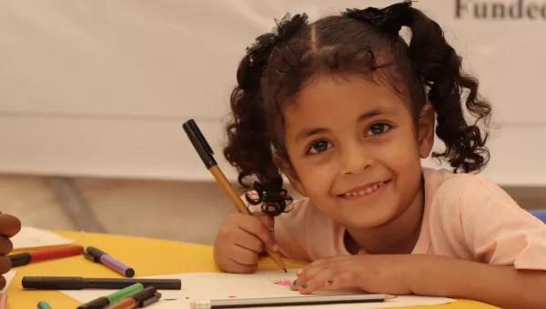 A young girl smiling at a War Child learning Centre. 