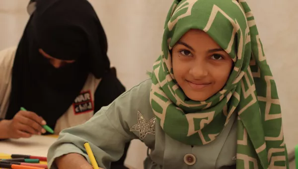 Girl draws pictures at a War Child child-friendly space in a camp in Yemen.