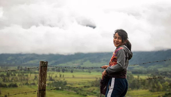 Child standing next to a field in Colombia.