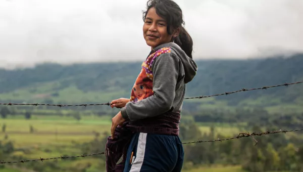 Child standing next to a field in Colombia.