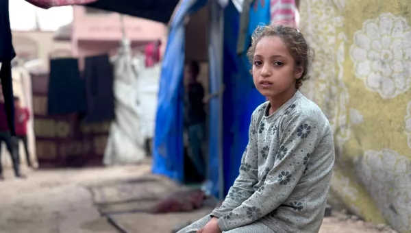 Girl sitting outside in a refugee camp in Gaza. 