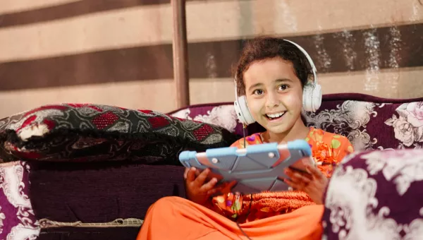 A child wearing headphones and taking part in Can't Wait to Learn.