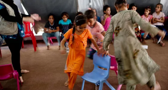 Little girls playing musical chairs in a War Child child-friendly centre.