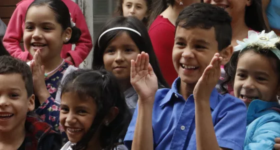 A group of children in Colombia laughing and clapping