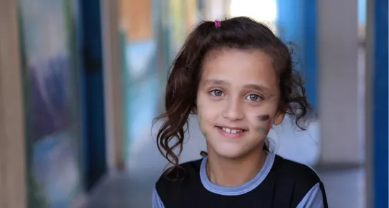 Girl from Gaza smiles at camera with paint on her face