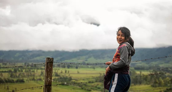 Child standing next to a field in Colombia.