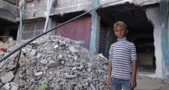 Boy in Gaza next to rubble