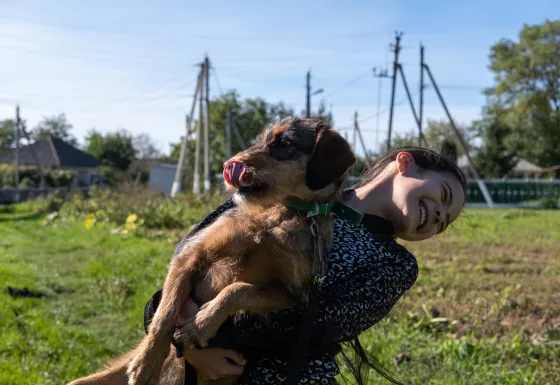 Galina, 8 years old, playing with her puppy in a park in Moldova