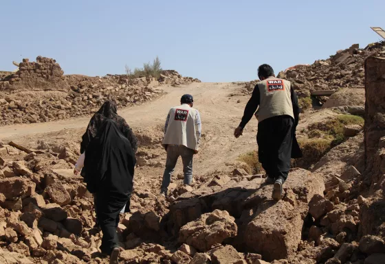 War Child staff walking over the rubble after the earthquake.