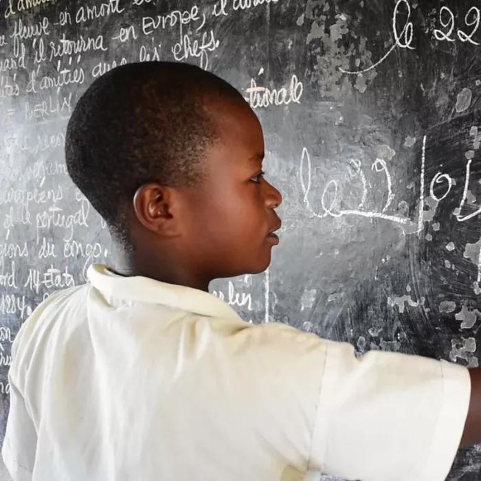 Lamegia writing on a chalkboard at school. 