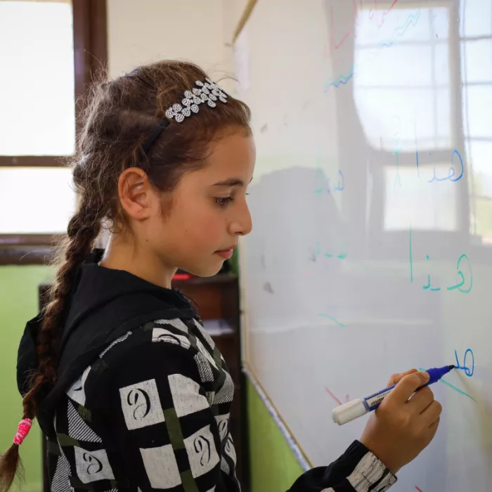 Farah drawing on a whiteboard. 